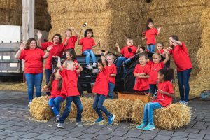 Mehrere Kinder spielen auf Strohballen