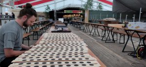 Ein Mann sitzt an einem Biertisch und wertet die Ergebnisse auf Zielscheiben aus